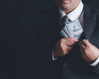 Man putting bribe money into pocket on black background, Concept for corruption, finance profit, bail and crime